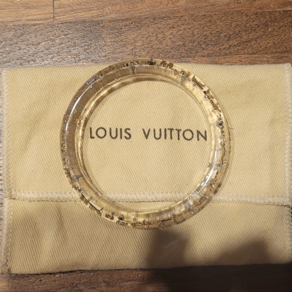 Authentic clear resin Louis Vuitton bracelet with gold lv and flower flakes.